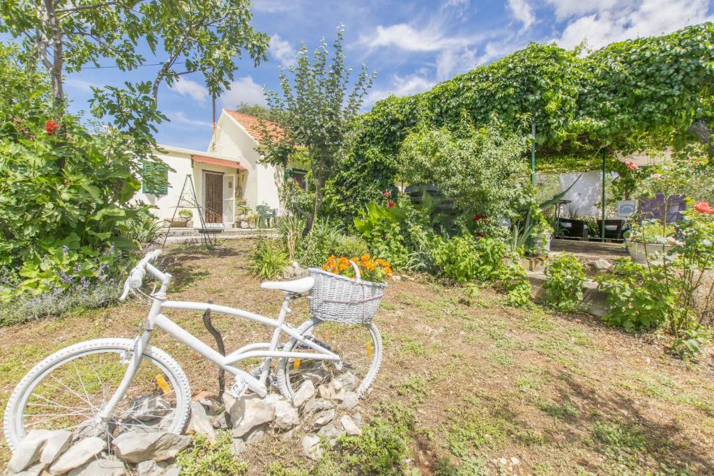 a white bike parked in the yard of a house at House Green Paradise in Vrpolje