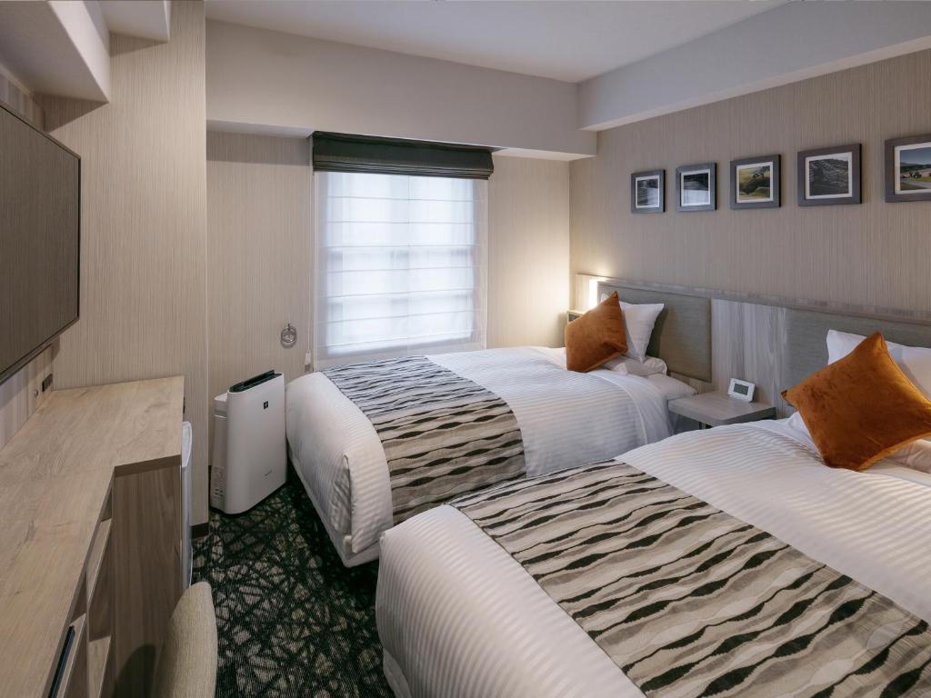 Postel nebo postele na pokoji v ubytování Hotel Mystays Kagoshima Tenmonkan Annex