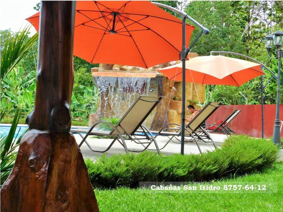 a group of chairs and umbrellas next to a fountain at Cabañas San Isidro in Ángeles