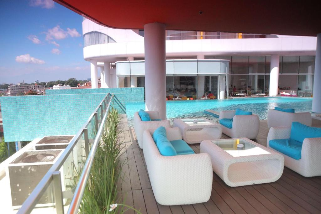 a balcony with chairs and a swimming pool at Sensa Hotel Bandung in Bandung