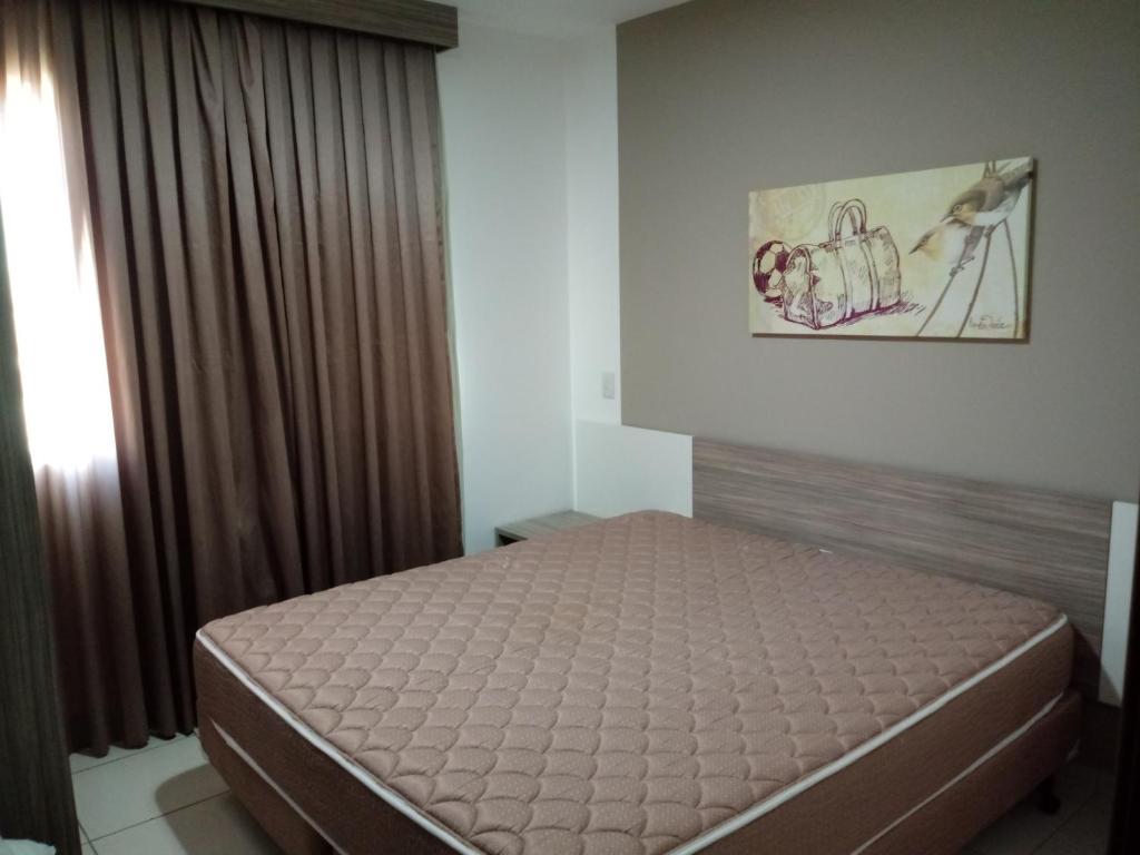 1 dormitorio con cama y ventana en Apartamento no Riviera Park, en Caldas Novas