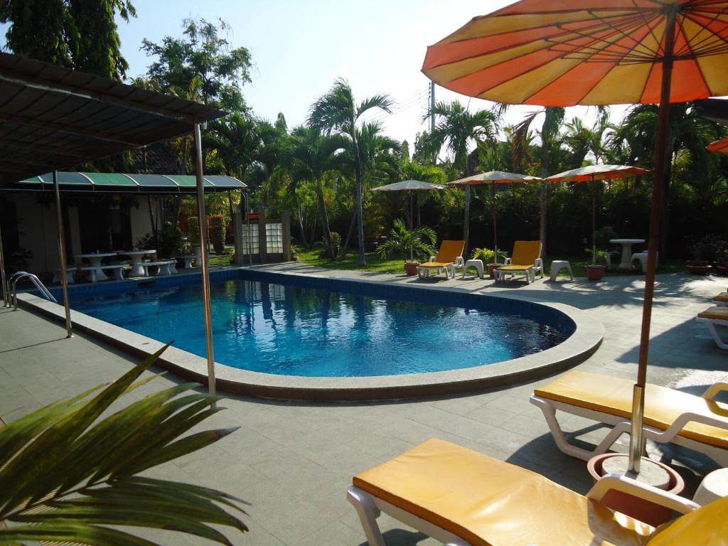 a swimming pool with umbrellas and chairs and a resort at Lonops Gay Paradise in Nong Prue