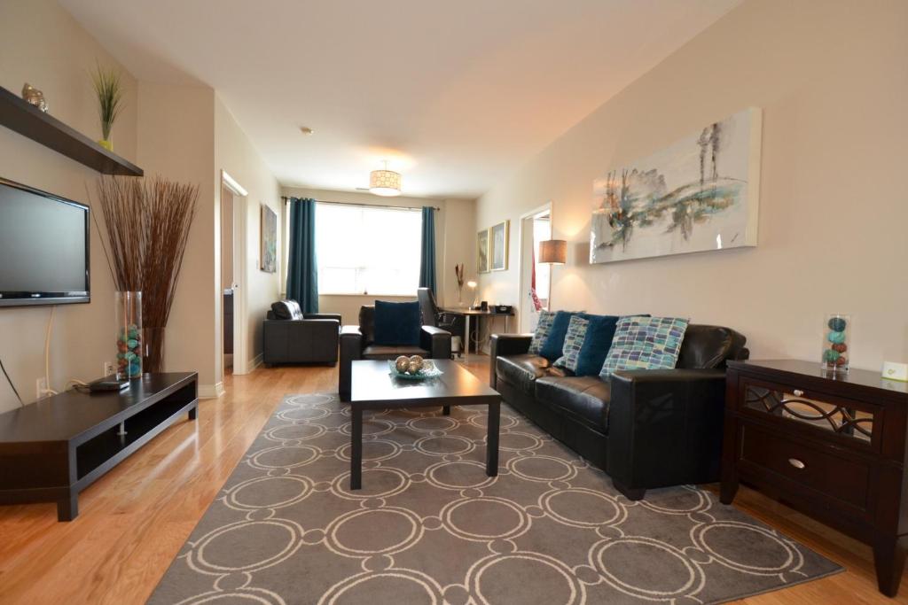 a living room with a couch and a table at The SoMa Furnished Residences in Hamilton