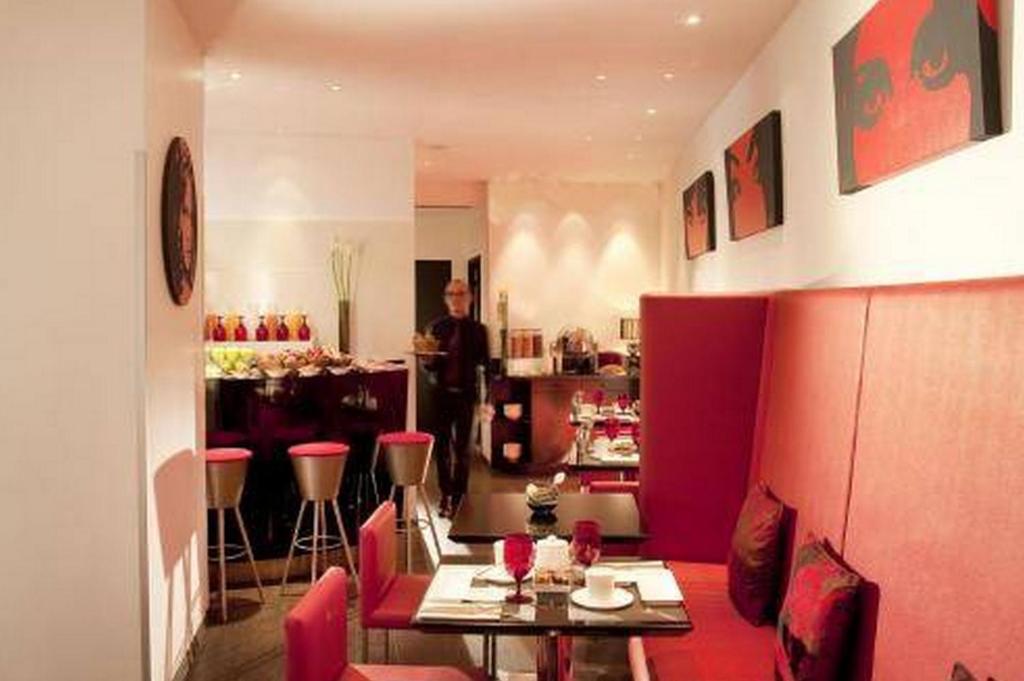 a room with a table and chairs and a man at Villathena in Paris