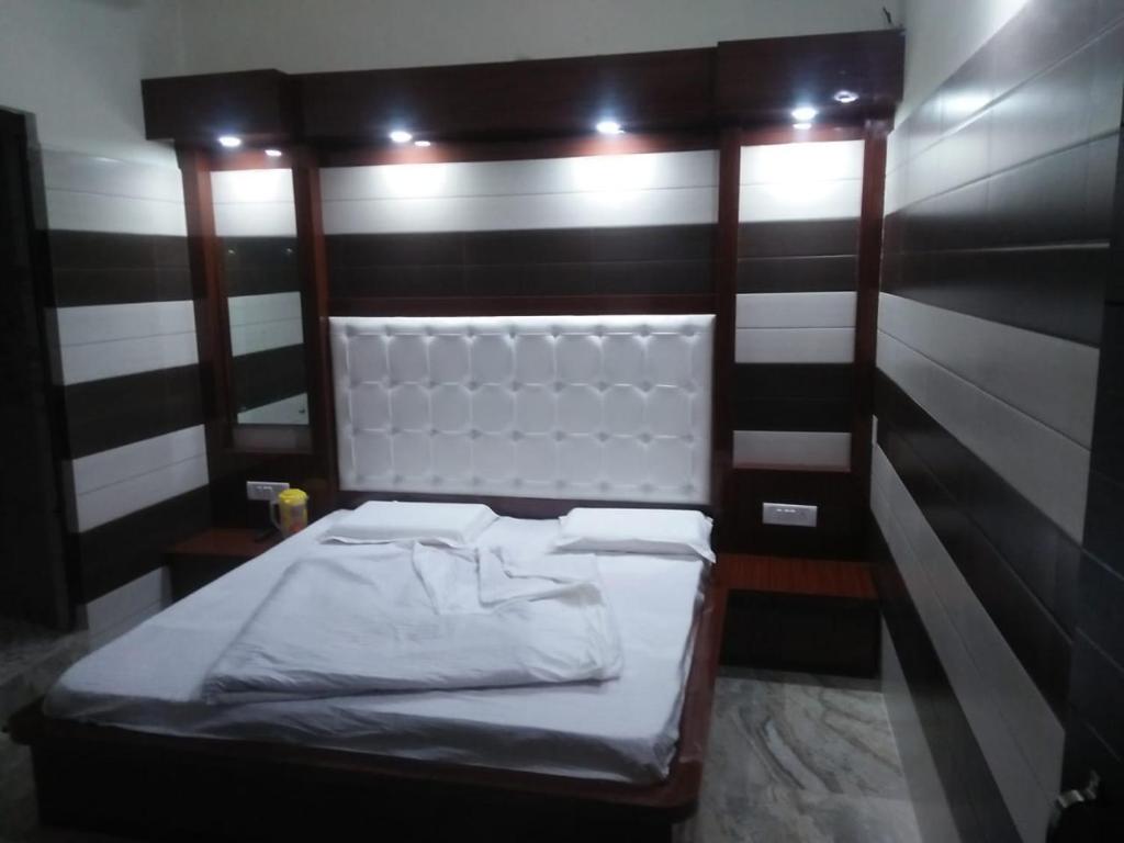 a small bed in a room with black and white stripes at Vidya Guest House in Katra