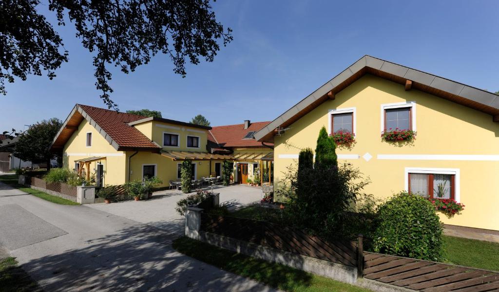 佩爾森貝格的住宿－Privatzimmer und Ferienwohnungen Leeb，前面有栅栏的黄色房子