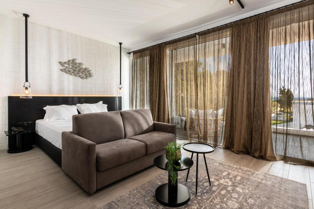 een hotelkamer met een bed en een bank bij Abacus Suites in Ayia Napa