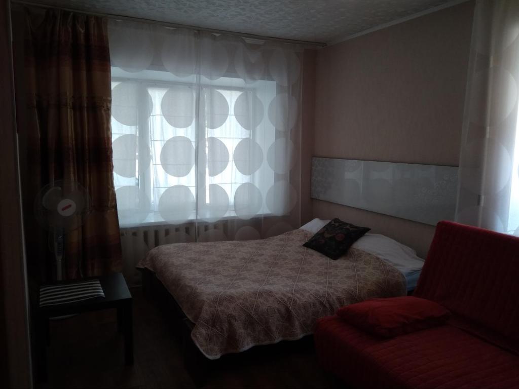 オレンブルクにあるApartment on prospekt Pobedyのベッドルーム1室(ベッド1台、窓、椅子付)