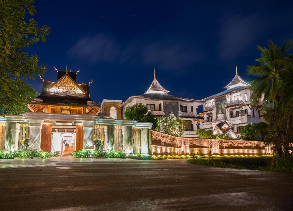 a resort with a building at night at Shinnabhura Historic Boutique Hotel in Phitsanulok