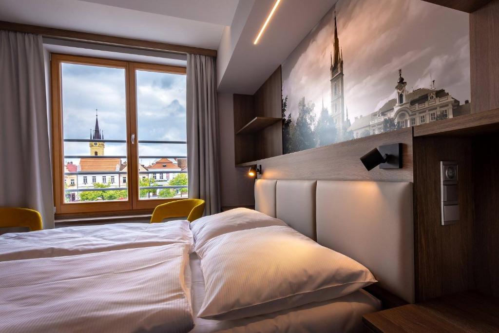 um quarto com uma cama grande e uma janela em Hotel Grand em Cáslav
