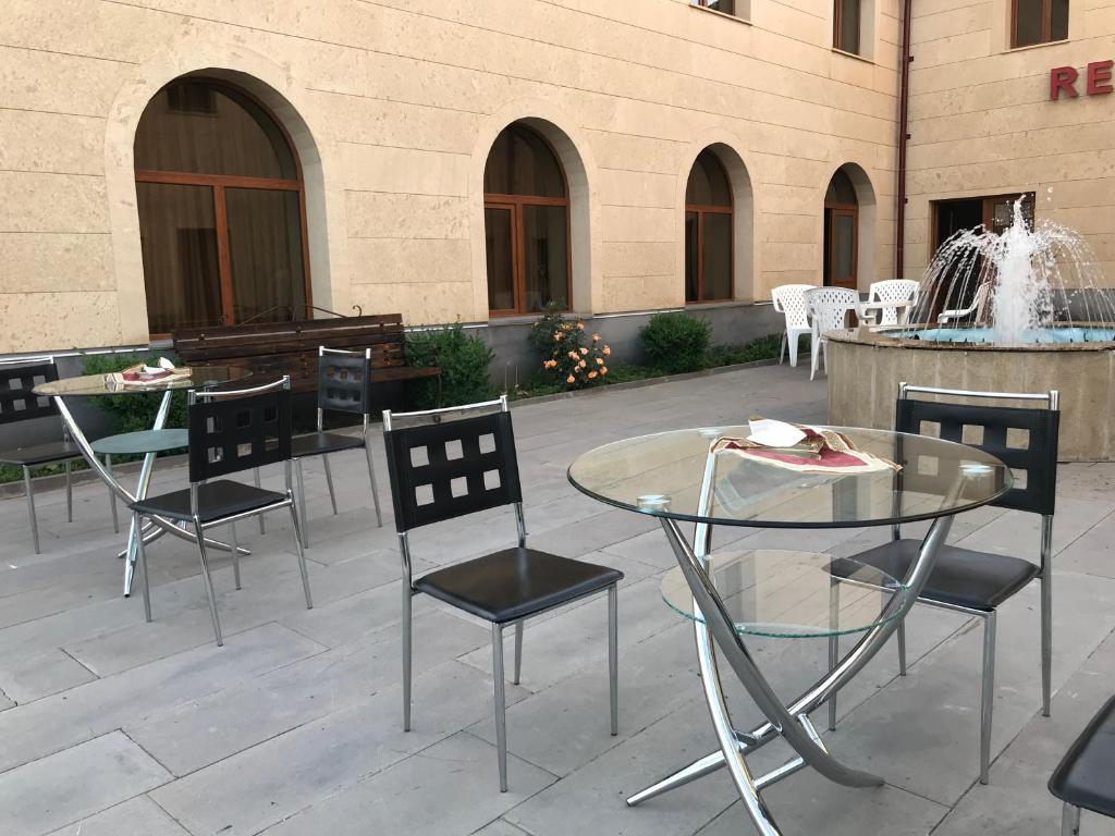 patio ze stołami, krzesłami i fontanną w obiekcie Armenia VanSevan Hotel w mieście Sewan