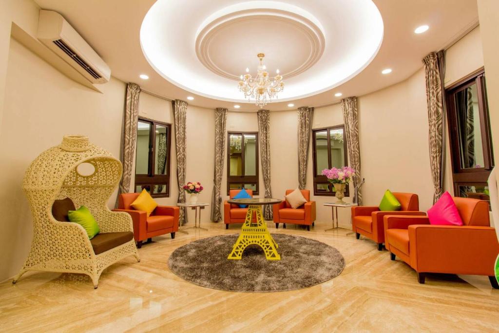 a living room with orange chairs and a table and a chandelier at Hliweng B&B in Yilan City