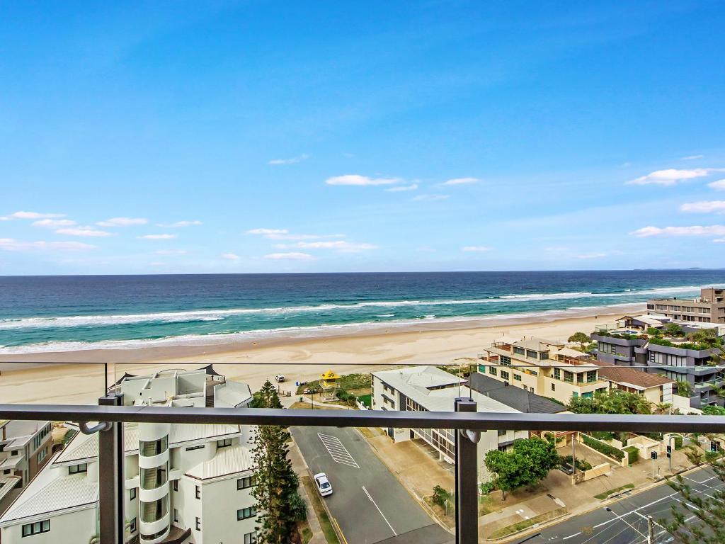 a view of a beach and the ocean from a balcony at Sunbird Beach Resort Main Beach in Gold Coast