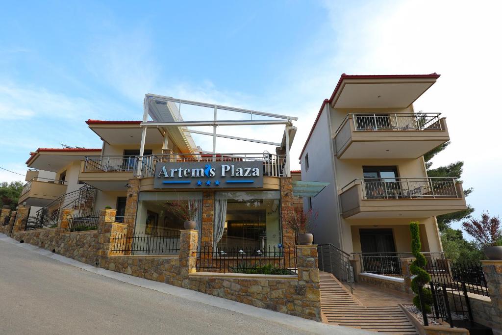 a building with a sign for an athens pizza at Artemis Plaza in Agia Paraskevi