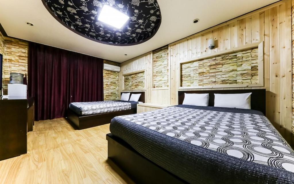 a bedroom with a bed and a bench in it at Venus Motel in Boryeong
