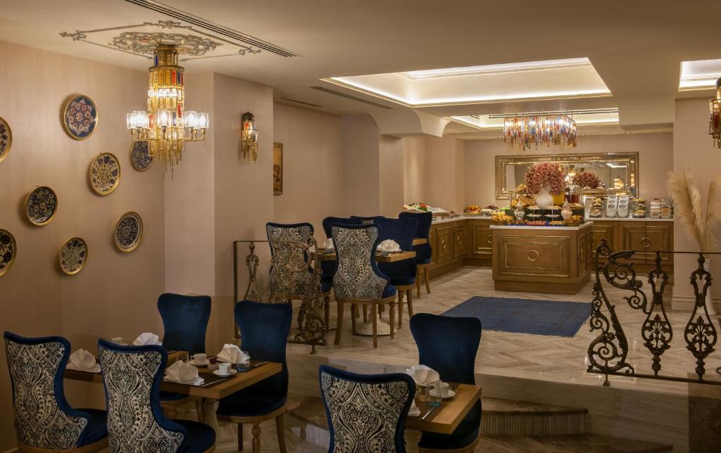 a restaurant with blue chairs and a table and a counter at Romance Istanbul Hotel Boutique Class in Istanbul