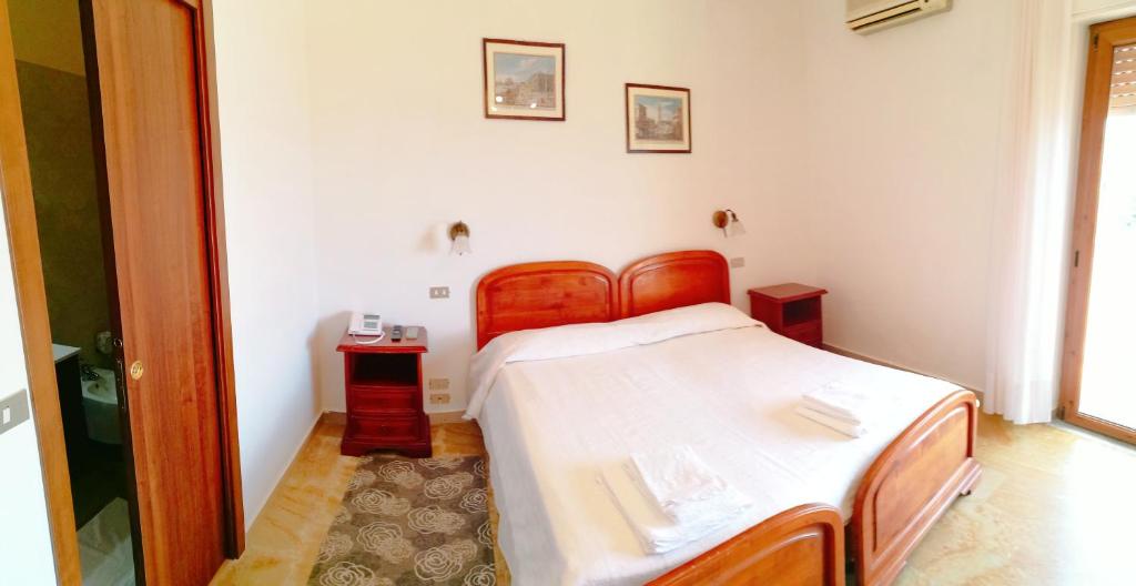 a bedroom with a bed and two night stands at PARADISO Hotel Ristorante in Reggio Calabria