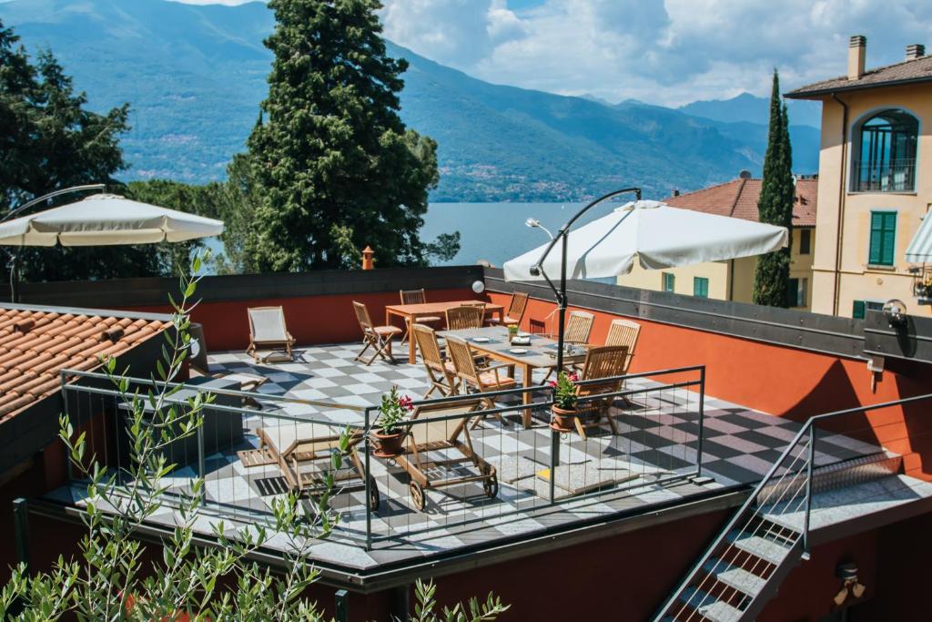 un patio con mesa y sillas en la parte superior de un edificio en Valle dei Mulini - Lake Como, en Bellano