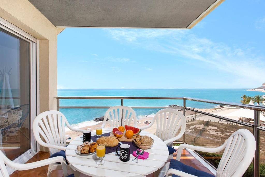 uma mesa com comida numa varanda com o oceano em Santa Susanna Skyline Apartment em Santa Susanna