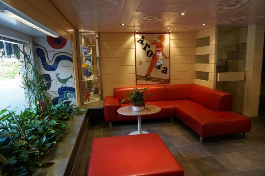 アローザにあるParadies 212の赤いソファとテーブルが備わる待合室