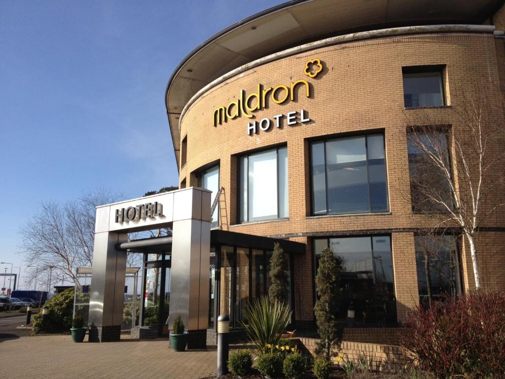 a building with a sign for a hotel at Maldron Hotel Belfast International Airport in Aldergrove