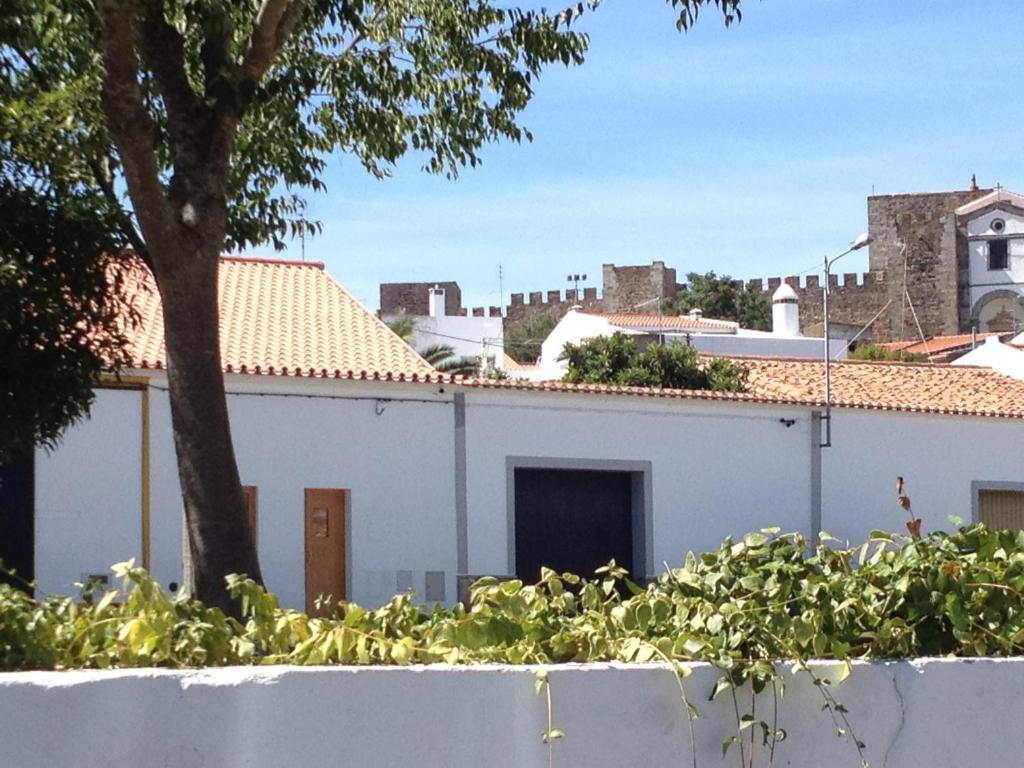 un edificio bianco con una porta e un albero di CASA NA VILA HISTÓRICA DE MOURÃO a Mourão
