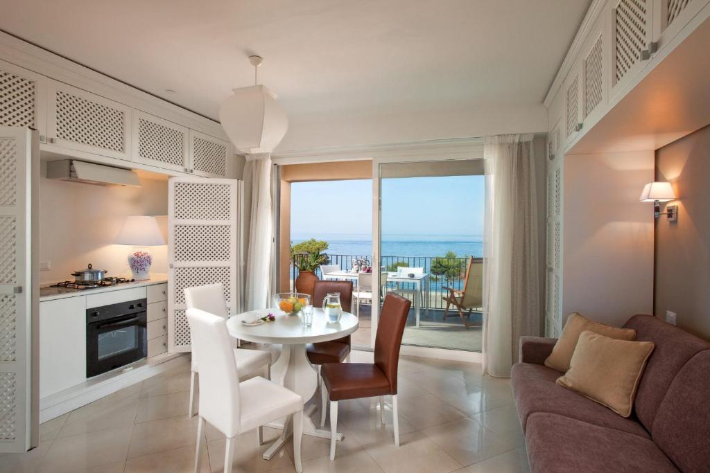 タオルミーナにあるTaormina Villa Oasis Residenceのキッチン、リビングルーム(テーブル、椅子付)