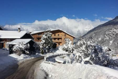 una carretera cubierta de nieve frente a un edificio en Spacious and stylish flat at the foot of the Mont-Blanc ideal for ski in ski out en Les Houches