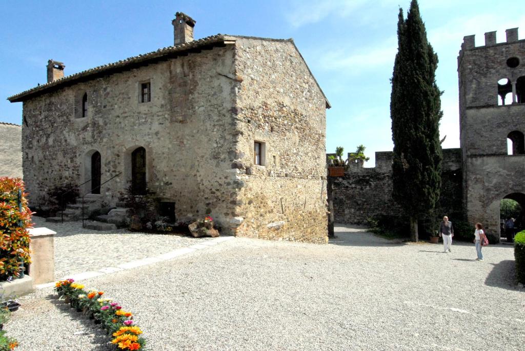 CastellaroにあるAntica Dimora dell'Ortolanoの花の前に建つ古い石造りの建物