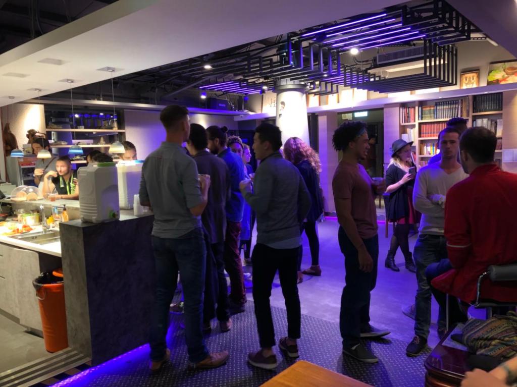 a group of people standing in a line at a bar at Taipei Discover Hostel in Taipei