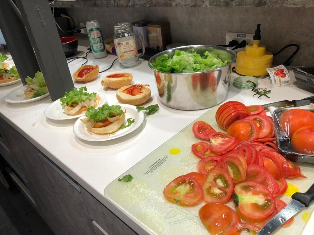 a counter with plates of tomatoes and vegetables on it at Taipei Discover Hostel in Taipei