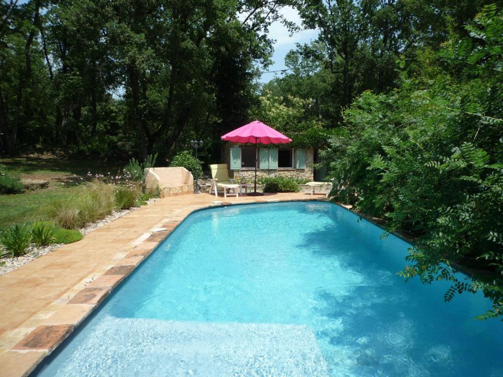 蒙托魯的住宿－拉羅斯戴斯唯特斯住宿加早餐旅館，一个带粉红色遮阳伞和房子的游泳池