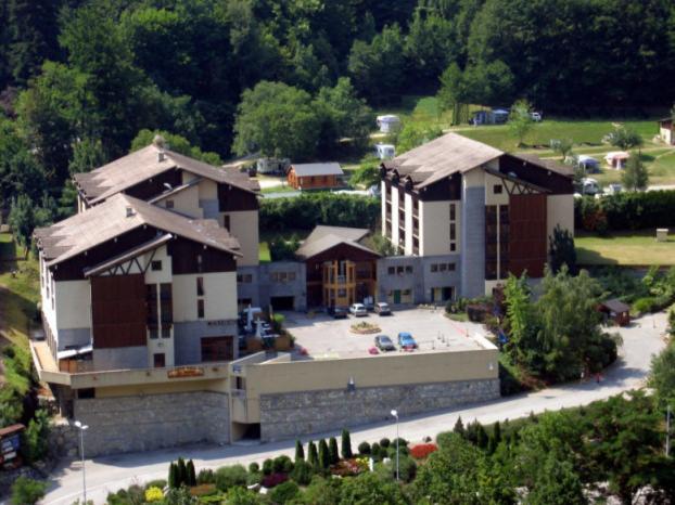 une vue aérienne sur un grand bâtiment avec un parking dans l'établissement Résidence Cybèle, à Brides-les-Bains