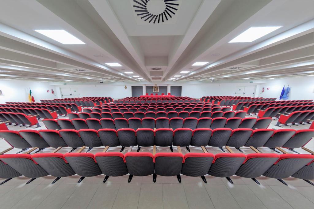 una sala conferenze vuota con sedie rosse di Casa per Ferie Sant'Anna a Matera