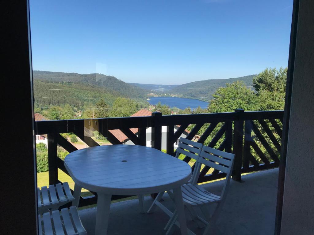 a table and chairs on a balcony with a view at Les Loges du Lac - Appartement avec Terrasse in Gérardmer