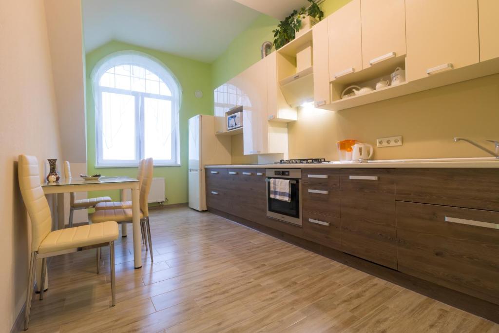 Gur'yevskにあるApart39 in Guryevsk on Zelionaya 22のキッチン(木製キャビネット、テーブル、椅子付)