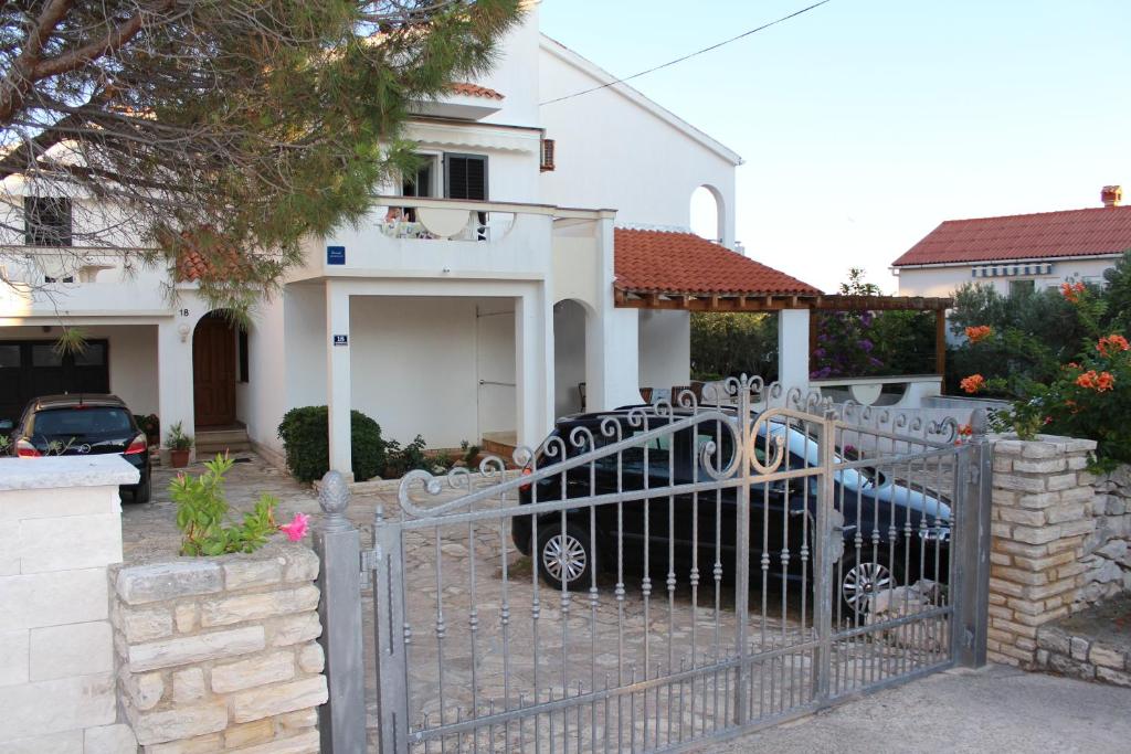 a car parked in front of a house with a gate at Small apartment Merica in Novalja