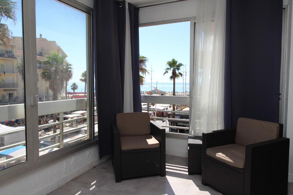 Habitación con 2 sillas y vistas a la playa en HACIENDA- Grand studio dans le centre avec vue mer en Canet-en-Roussillon