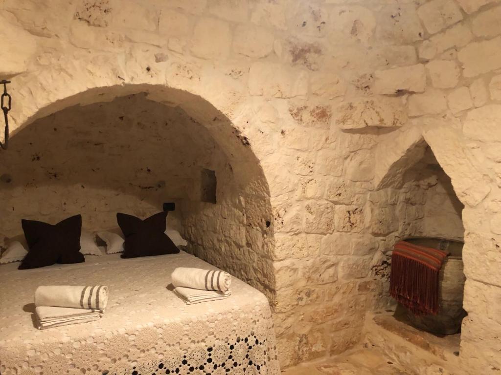 オストゥーニにあるI Love Trullo - Country Boutique Apartments - Villa Laura Ostuniの石壁のベッドルーム1室