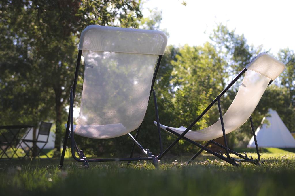 two chairs sitting in the grass in a field at L&#39;Escale des Châteaux de la Loire in Angé