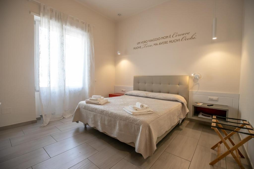 a bedroom with a bed with towels on it at Residenza Eleonora - Amami Collection in Salerno