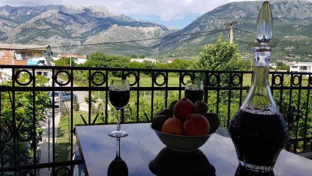 a table with a bowl of fruit and two wine glasses at Guesthouse Branko in Bar