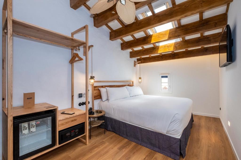 a bedroom with a bed and a tv at Nao Catedral Boutique Hotel in Ciutadella