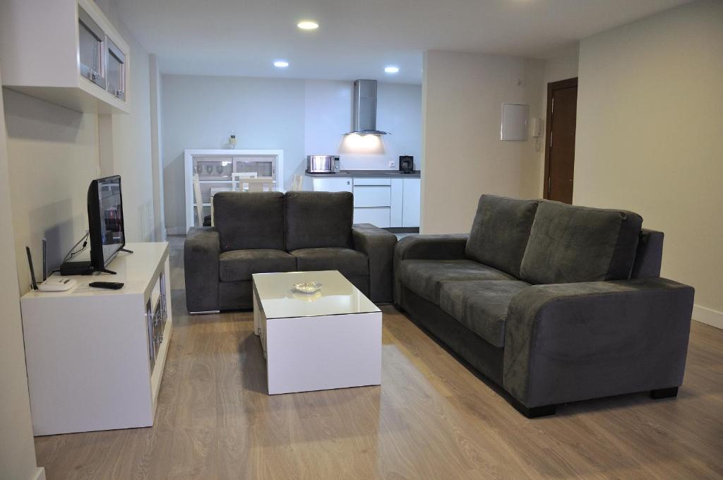 a living room with two chairs and a couch and a table at Apartamentos Sábora in Ronda