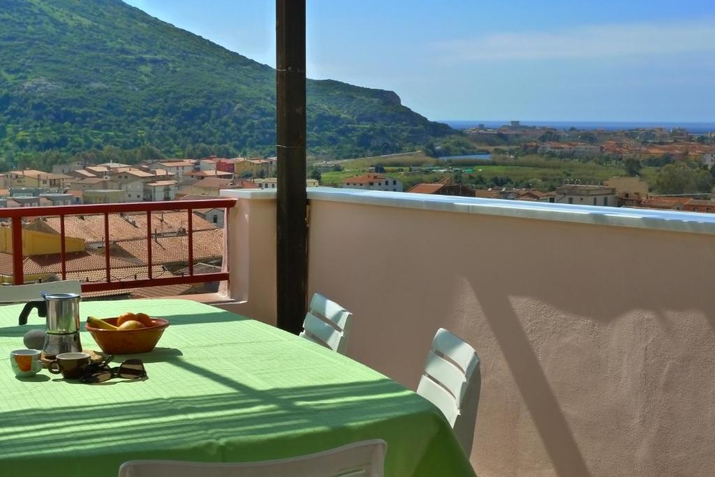 a table with a bowl of fruit on a balcony at Guesthouse Bosa di Giuseppe in Bosa