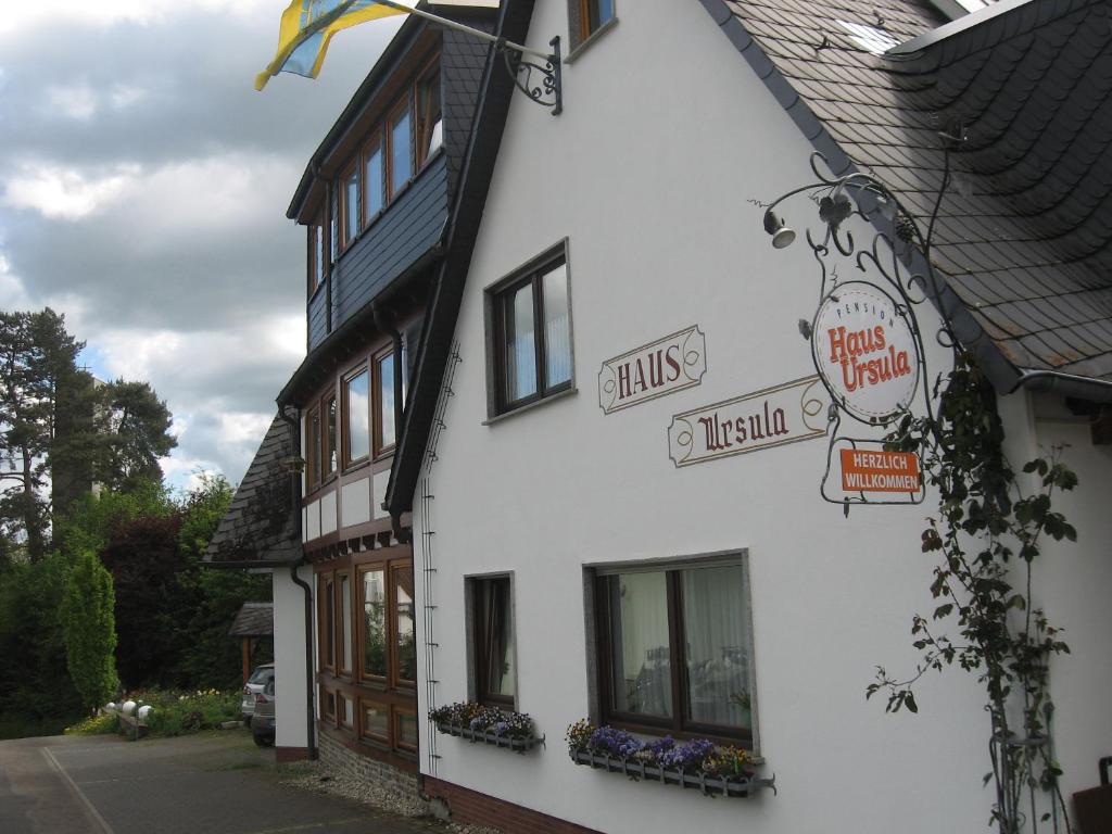 a white building with signs on the side of it at Pension Haus Ursula in Koblenz