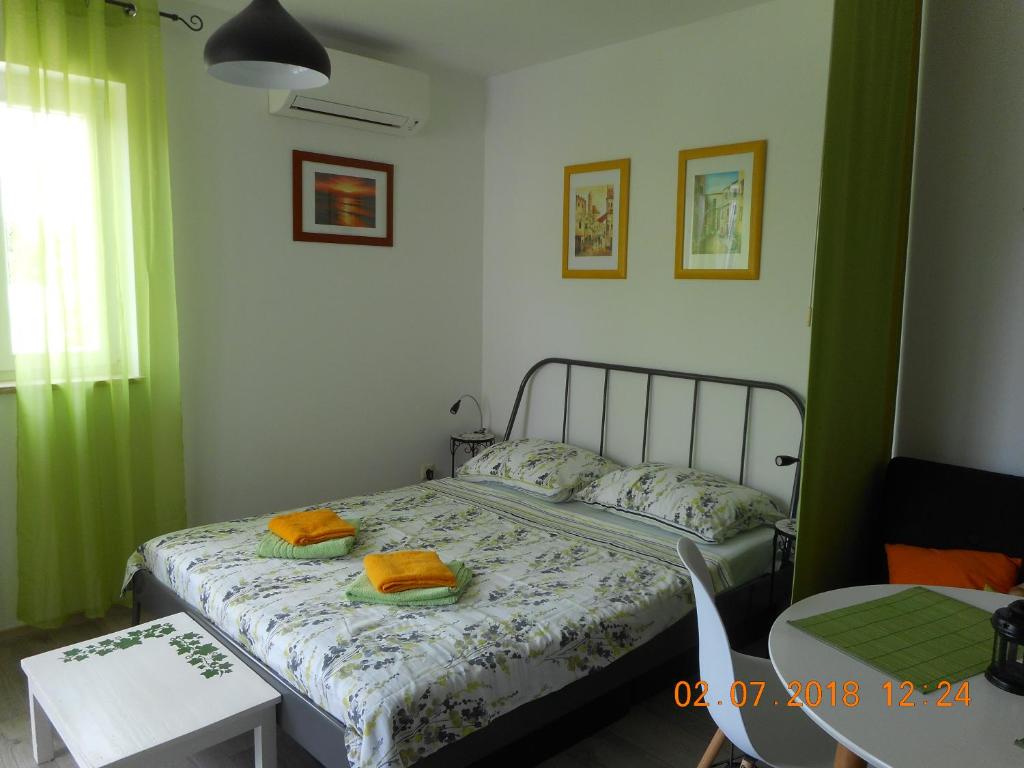 sypialnia z łóżkiem i dwoma ręcznikami na nim w obiekcie Studio Relax Punat w mieście Punat