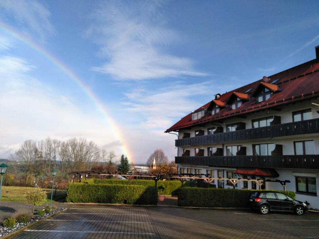 een regenboog in de lucht achter een gebouw bij Hotel Drei Konige in Schramberg