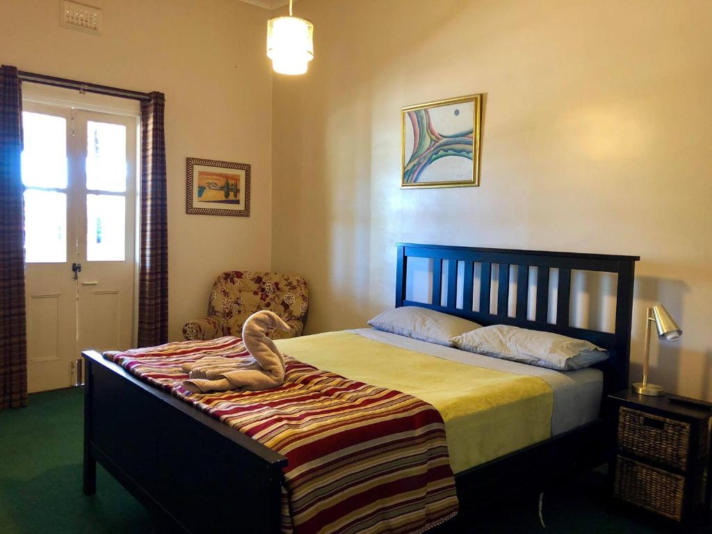 ein Schlafzimmer mit einem Bett mit einem ausgestopften Tier darauf in der Unterkunft Junction Hotel Moora in Moora