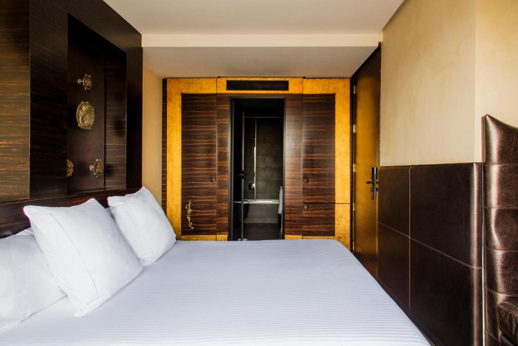 a bedroom with a large bed with white pillows at Hotel Bagués, a Small Luxury Hotel of the World in Barcelona